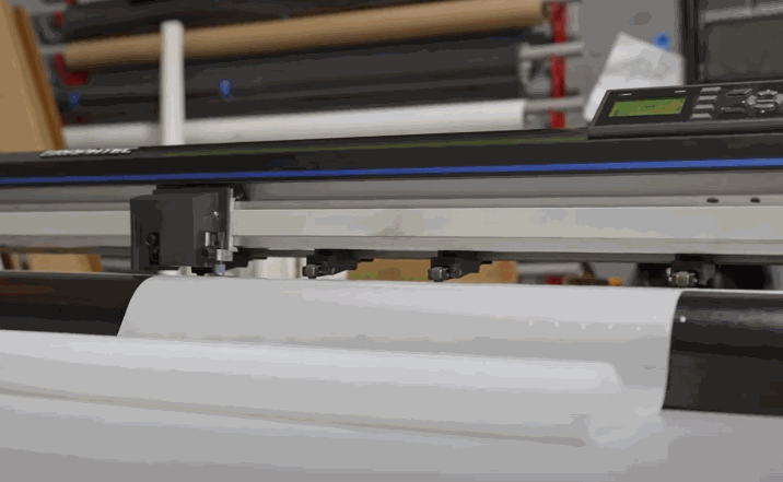 Machine cutting protection film to precise vehicle measurements for a custom fit.